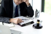 Lawyer is Looking through a Case File Thoughtfully and Stressed To Find ... How Can I Find A Good Lawyer For My Case